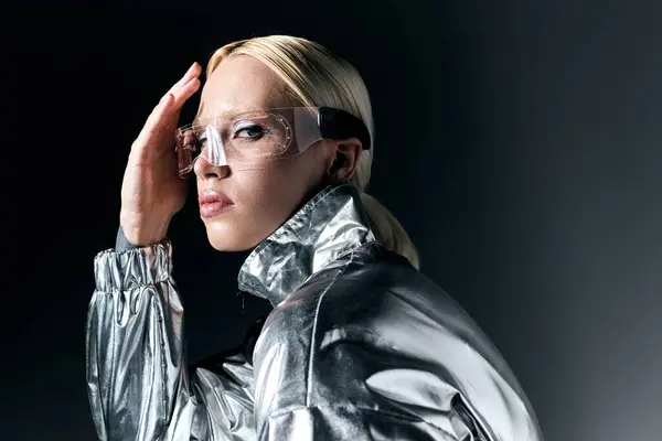 Belle femme particulière en lunettes futuristes regardant la caméra sur fond gris foncé — Photo de stock