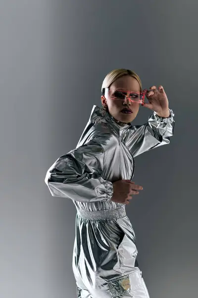 Bizarre Frau mit Science-Fiction-Brille in futuristischer Kleidung, die Roboterbewegungen macht und in die Kamera schaut — Stockfoto