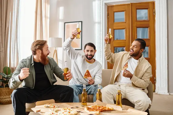 Trois hommes gais et interracial en tenue décontractée dégustent bière et pizza ensemble sur un canapé confortable. — Photo de stock