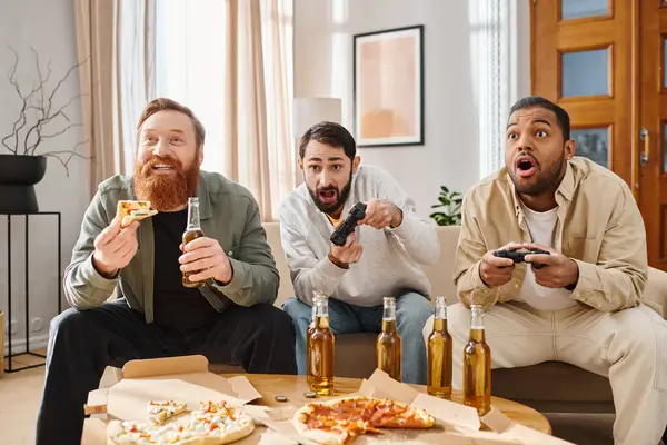 Tres hombres alegres e interraciales en atuendo casual disfrutando de pizza en una mesa, mostrando la belleza de la amistad y la unión. - foto de stock