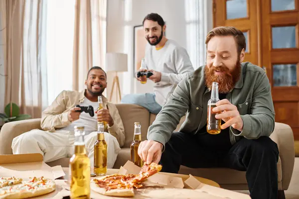 Trois beaux hommes interracial dégustant de la pizza et de la bière lors d'un rassemblement décontracté, partageant des rires et de bons moments à table. — Photo de stock
