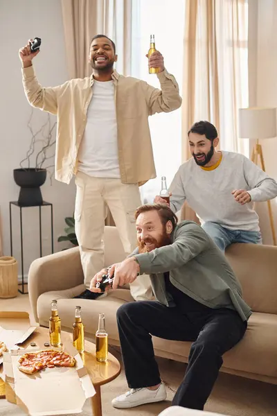 Drei interrassische, stilvolle Männer genießen ein lockeres Beisammensein voller Lachen und Kameradschaft in einer gemütlichen Wohnzimmeratmosphäre. — Stockfoto