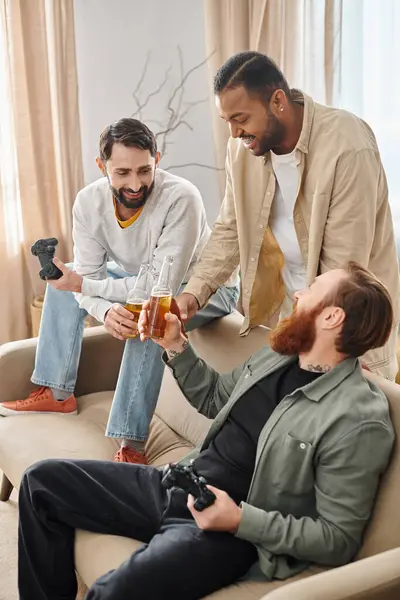 Three cheerful, handsome, interracial men in casual attire enjoying each others company on top of a couch. — Stock Photo