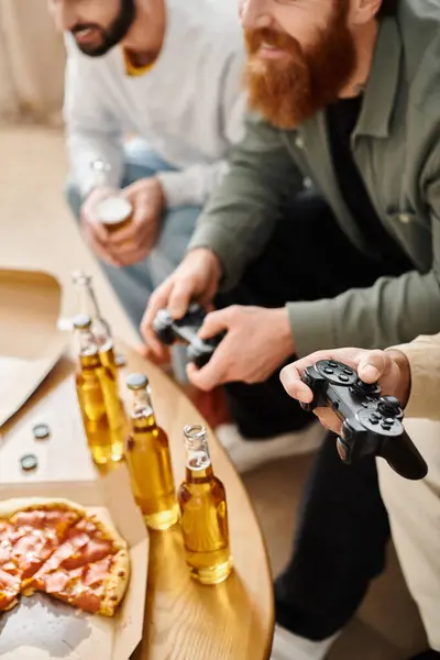 Deux hommes, d'origines raciales différentes, s'engagent dans une séance de jeu vidéo amicale sur un canapé en vêtements décontractés, appréciant le rire et la camaraderie. — Photo de stock