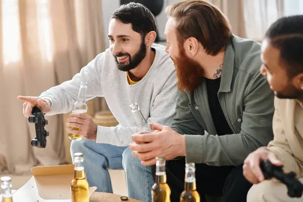 Three cheerful, interracial men enjoy a casual gathering, laughing and chatting over bottles of beer on a table. — Stock Photo