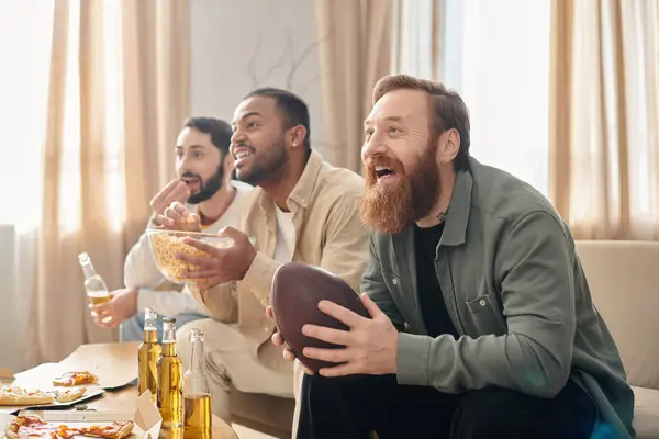 Trois beaux et joyeux hommes de différentes races dégustant des pizzas à table, habillés avec désinvolture et partageant un moment d'amitié. — Photo de stock