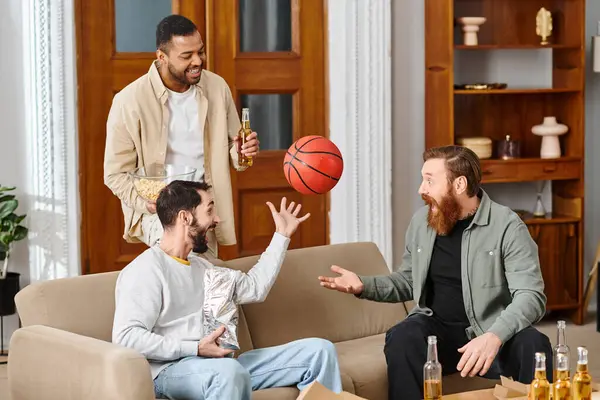 Tres hombres guapos y alegres de diferentes razas juegan un intenso juego de baloncesto, mostrando atletismo, trabajo en equipo y camaradería.. - foto de stock