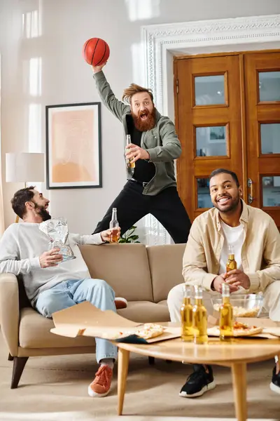 Tres hombres guapos de diferentes etnias charlando y riendo juntos en una acogedora sala de estar, mostrando amistad y camaradería. - foto de stock