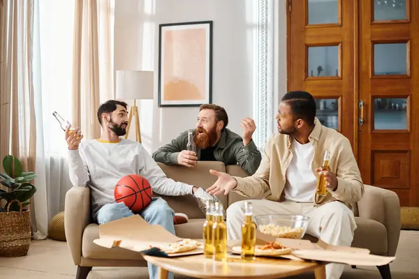 Tres hombres alegres e interraciales sentados alegremente encima de un sofá en atuendo casual, disfrutando de su tiempo juntos. - foto de stock