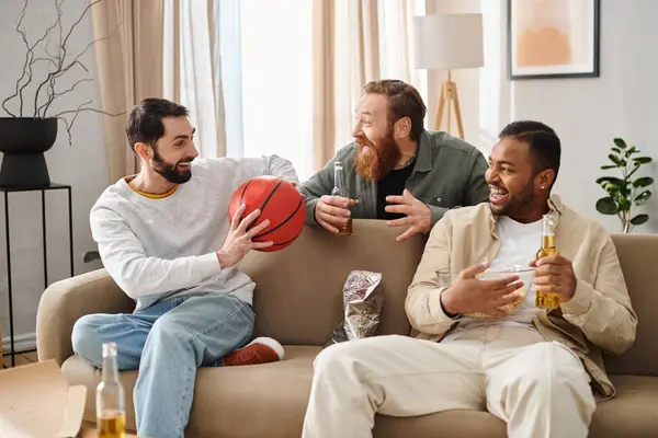 Three interracial handsome men in casual attire bonding and laughing happily while sitting on top of a couch. — Stock Photo