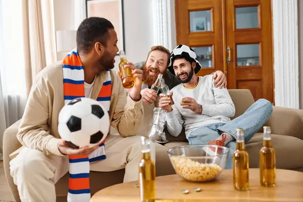 Tres hombres guapos y alegres de diferentes etnias sentados juntos en un sofá, exudando felicidad y amistad en atuendo casual. - foto de stock