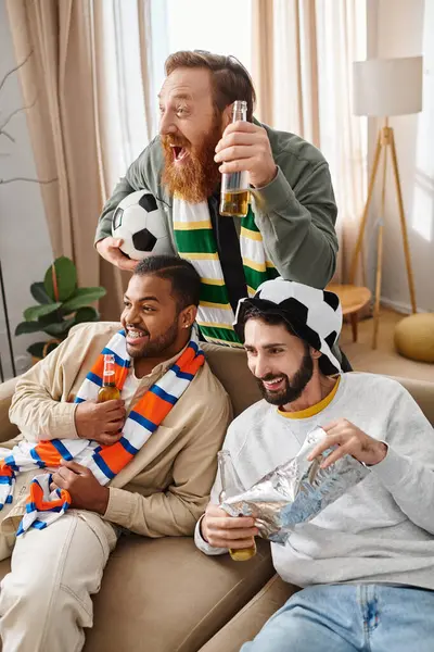 Three handsome, cheerful men of different ethnicities sit atop a couch, radiating warmth and friendship in a casual setting. — Stock Photo