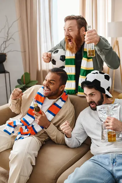 Three cheerful, interracial men in casual attire happily chatting and laughing while sitting on top of a sofa. — Stock Photo