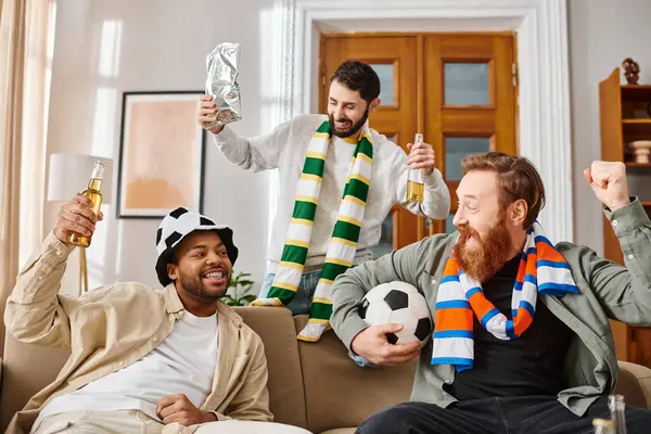 Three handsome men, different ethnicities, dressed casually, share joy atop a couch. — Stock Photo