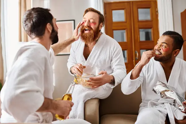 Three cheerful, diverse men wearing bathrobes sharing a moment of togetherness and friendship. — Stock Photo