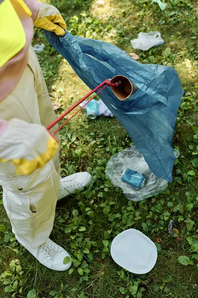 African american man cleaning park and holding blue bag next to his wife — Stock Photo
