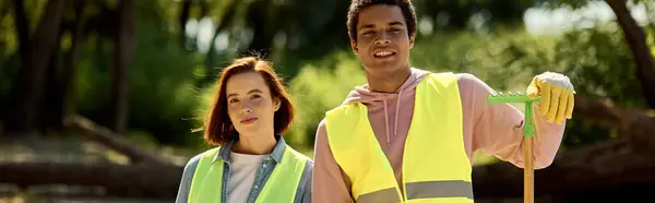 A socially active diverse loving couple wearing safety vests and gloves, cleaning a park together. — Stock Photo