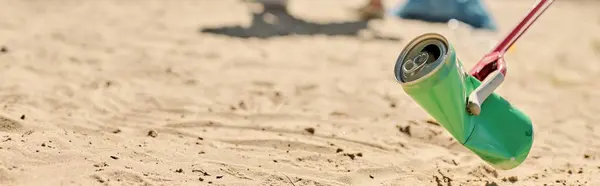 Una lattina di soda penzola da una corda sulla spiaggia, gettando ombre giocose nella sabbia. — Foto stock