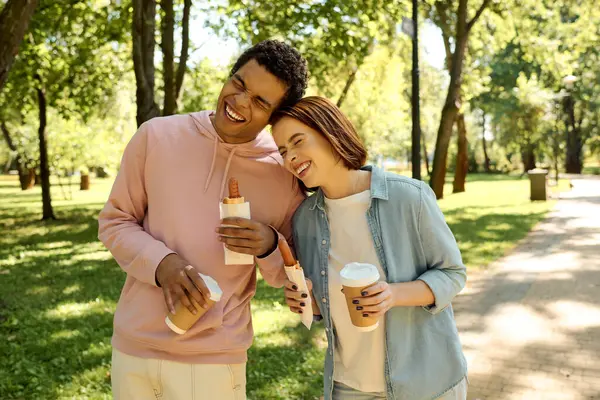 Ein Mann und eine Frau in lebendiger Kleidung stehen eng beieinander in einem Park und strahlen Liebe und Kameradschaft aus.. — Stockfoto