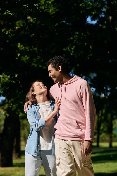 A diverse couple, dressed vibrantly, strolling through a peaceful park, enjoying each others company. — Stock Photo