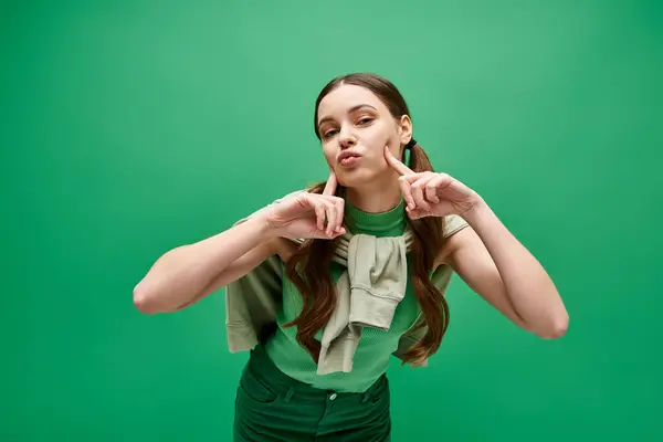 Una giovane, bella donna sulla ventina posa in una camicia verde per un ritratto professionale in uno studio elegante. — Foto stock