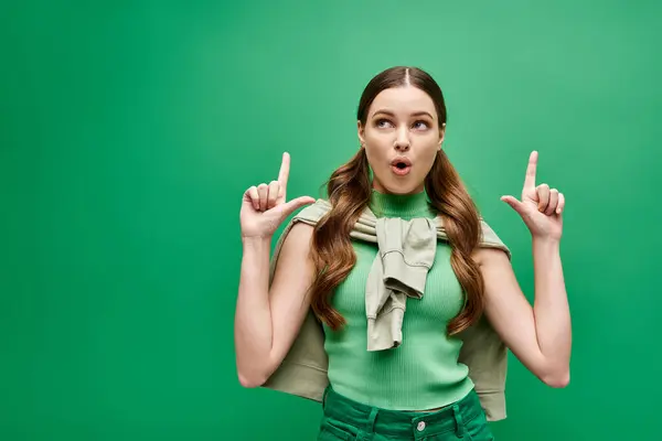 Una giovane ventenne indossa una camicia verde e solleva due dita in un gesto. — Foto stock