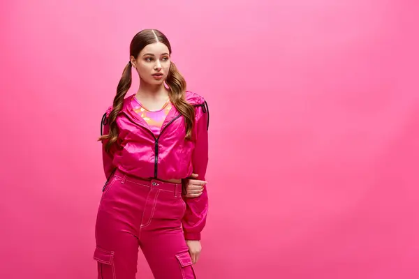 A stylish woman in her 20s is confidently posing for a portrait in a pink outfit, exuding elegance and beauty. — Stock Photo