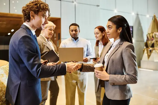 An interracial man and woman in business attire shaking hands. — Stock Photo