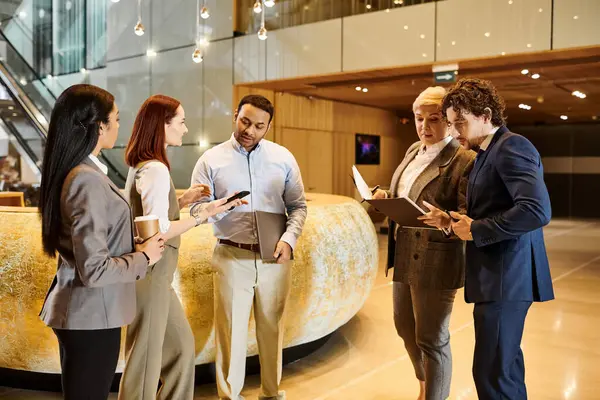 Multicultural professionals engaged in discussion in a lobby. — Stock Photo
