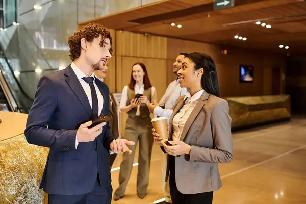 Un homme et une femme interracial en costume d'affaires engagés dans la conversation. — Photo de stock