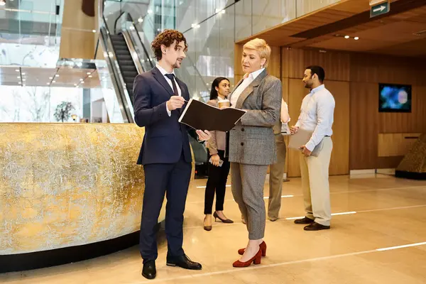 A man and woman in suits stand together. — Stock Photo