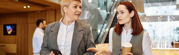 Two women of different races are standing and conversing. — Stock Photo