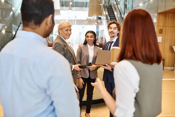 Une équipe d'affaires multiculturelle collabore dans un hall élégant. — Photo de stock