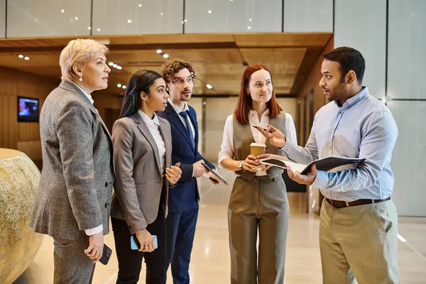 A diverse group of business professionals stand closely together in a circle, engaging in discussion. — Stock Photo