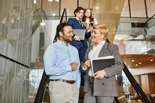 Profesionales de negocios multiculturales en trajes bajan escaleras juntos. — Stock Photo