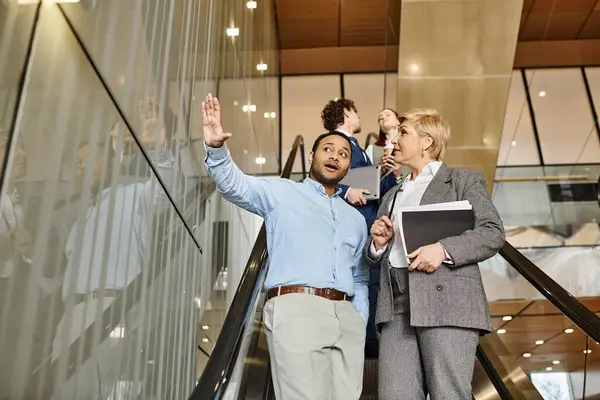 A diverse group of business professionals standing on top of an escalator in unity. — Stock Photo
