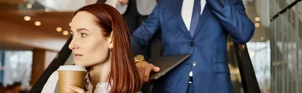 Una mujer sostiene una taza de café frente a un hombre. - foto de stock