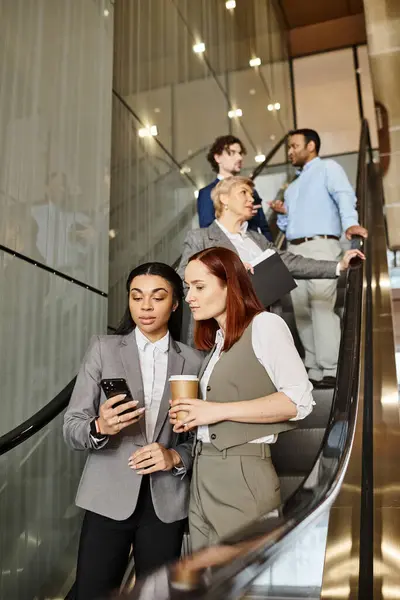 Diverse group of business people standing on escalator, moving upwards. — Stock Photo