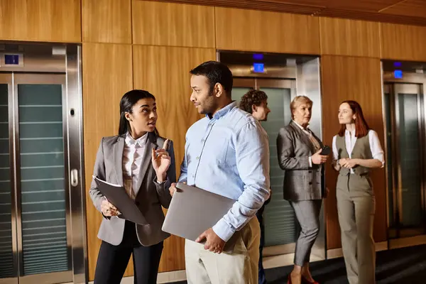 Un groupe diversifié de gens d'affaires debout ensemble devant plusieurs ascenseurs. — Photo de stock