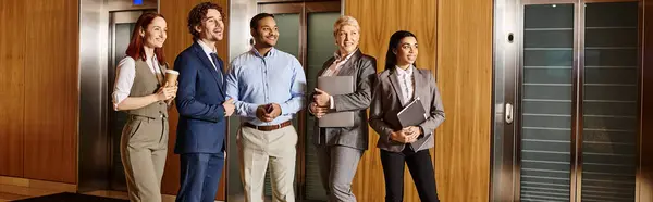 Diverse business team waits in front of elevator. — Stock Photo