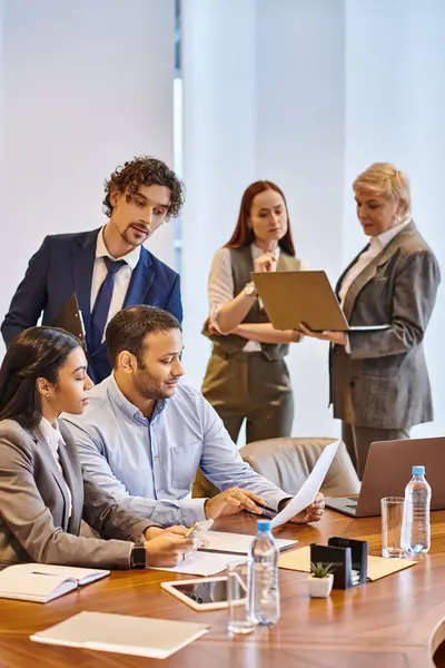Multiracial business team collaborating around a conference table. — Stock Photo