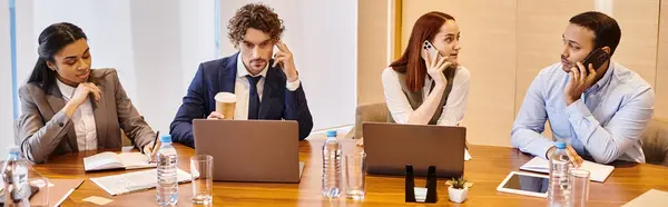 Diverse professionals working on laptops around a table. — Stock Photo