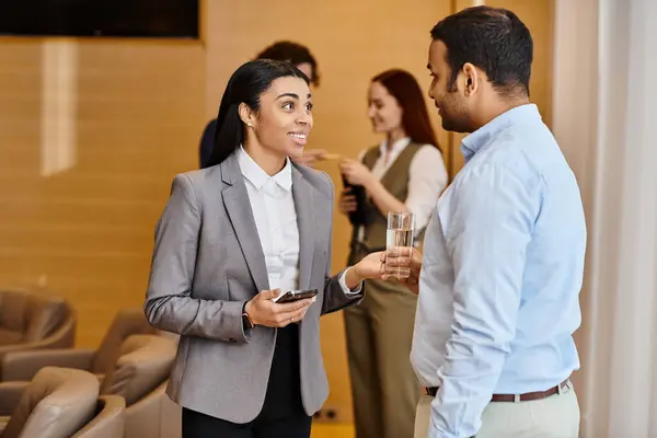 Une femme en costume d'affaires conversant avec un homme en costume. — Photo de stock