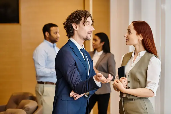 A man and woman in suits engaged in conversation. — Stock Photo