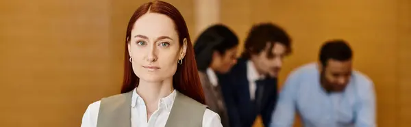 A woman confidently stands before a group of men, diverse in ethnicity, in a business setting. — Stock Photo