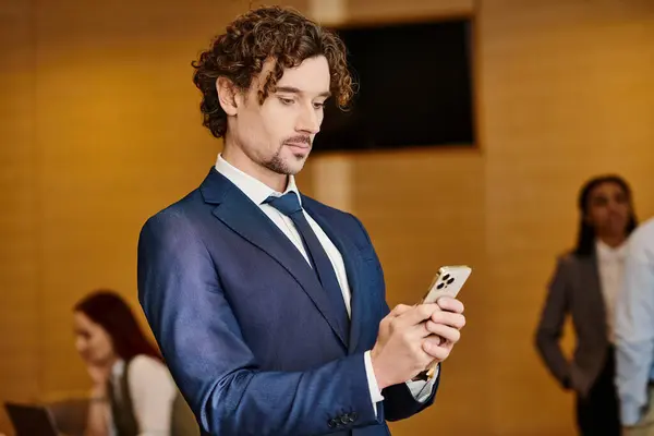 A stylish man in a suit engrossed in his cell phone. — Stock Photo