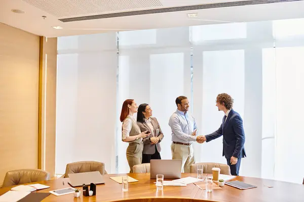 Diverse business professionals engaging in a handshake gesture inside a conference room. — Stock Photo
