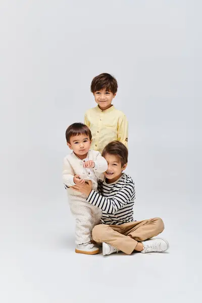Um grupo diversificado de crianças asiáticas posando juntas em um estúdio em um fundo cinza. — Fotografia de Stock