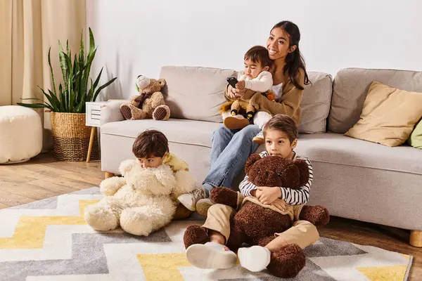 A young Asian mother sits on a couch with her little sons in their cozy living room, sharing a moment of togetherness. — Stock Photo