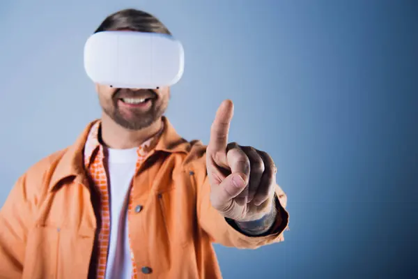 Um homem em um fone de ouvido VR fica com uma venda apontando diretamente para a câmera, incorporando uma perspectiva única. — Fotografia de Stock
